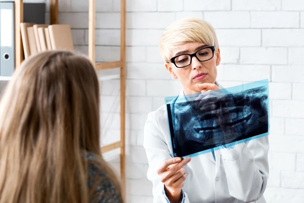 Clearly Dental Riverwood dentist discusses an X-ray with a patient to determine treatment options.